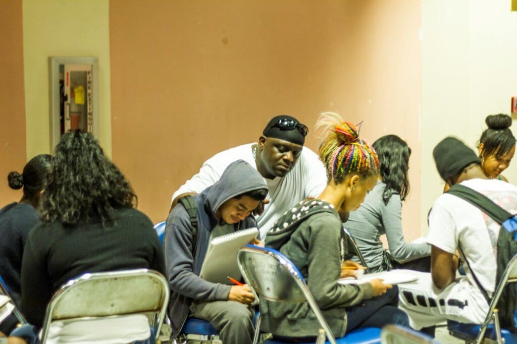 A group of people sitting in a room with laptops.