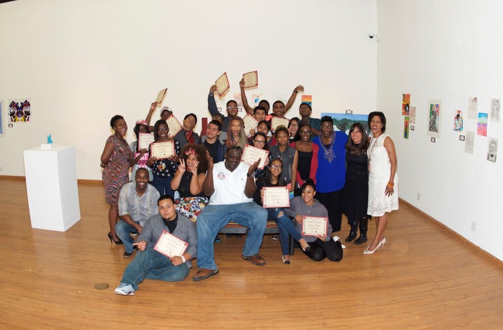 A group of people posing for a picture in an art gallery.