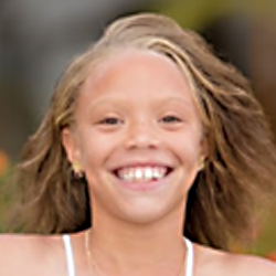 A young girl with long hair smiling for the camera.