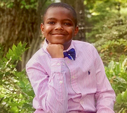 A young boy wearing a pink shirt and bow tie.