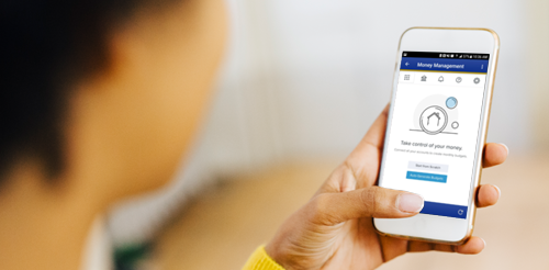 A woman holding a smart phone with a smart home app on it.