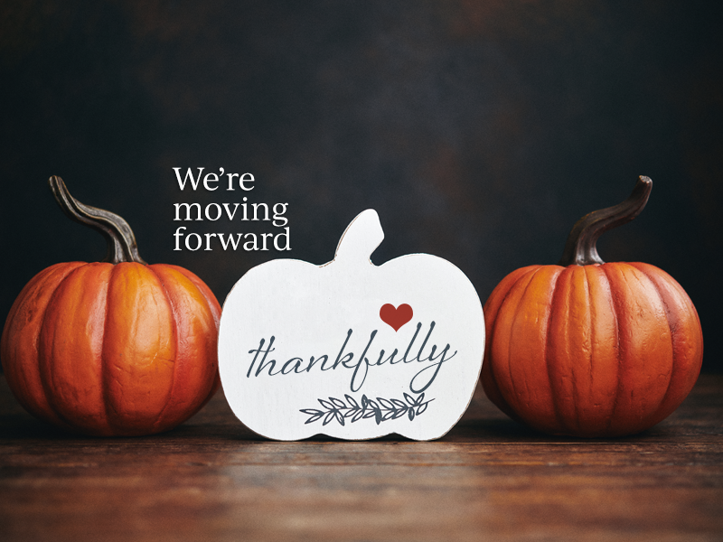 Three pumpkins with the words we're moving forward thankful.