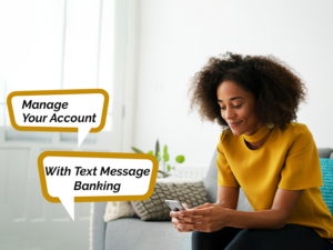 A woman sitting on a couch with a cell phone and text message banking.