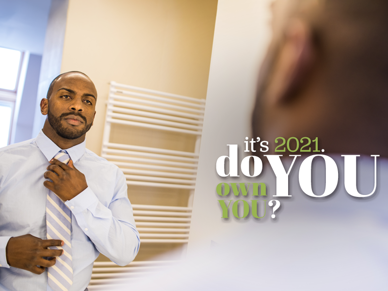 A man is adjusting his tie in front of a mirror.