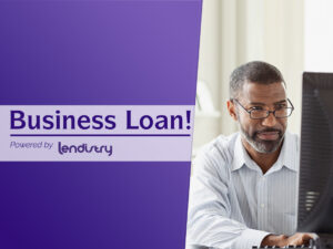 A man sitting at a computer with the words business loan.