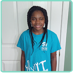 A young girl wearing a blue t - shirt.