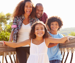 A family is posing for a picture on a bridge.