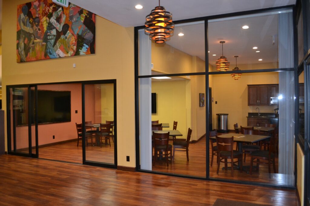 A dining room with wooden floors and a painting on the wall.