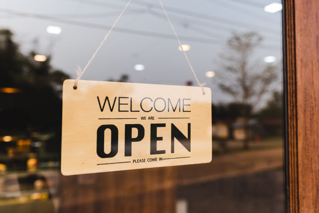 Open sign in hanging in front door of a store