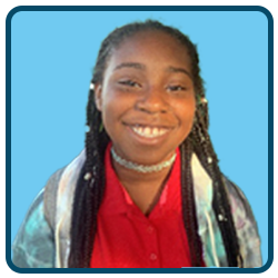 A young girl with dreadlocks smiling in front of a blue background.
