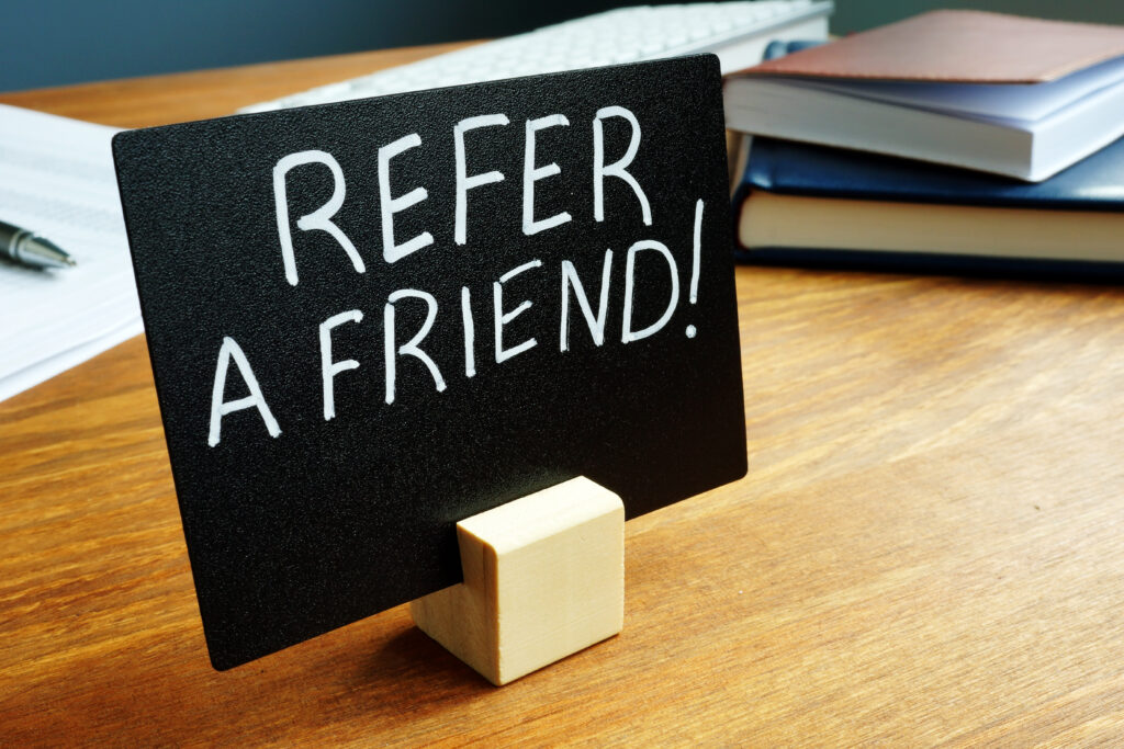 a desk with a chalkboard sign that reads refer a friend