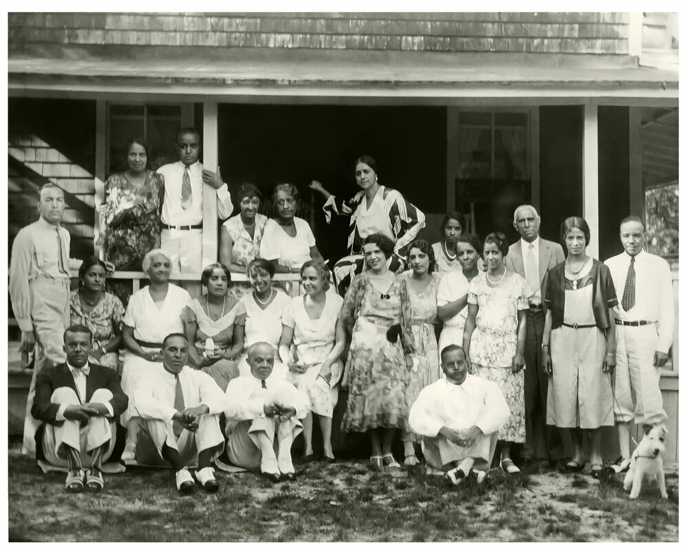 A group of people posing in front of a house.