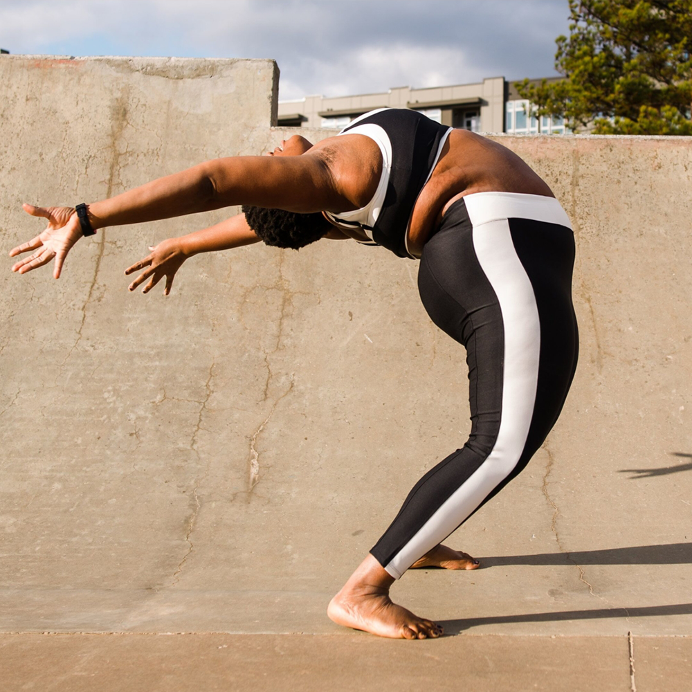 A woman doing a yoga pose on a skateboard.