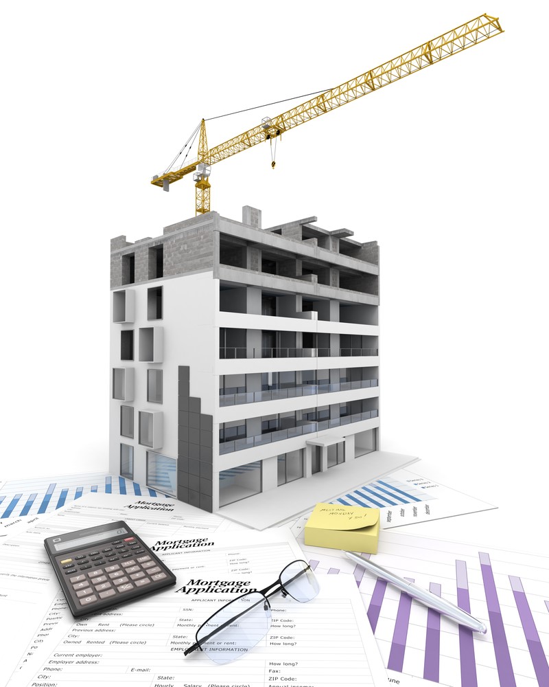 A construction crane sits on top of a building with papers and a calculator.