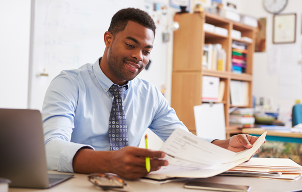 A man sitting at a desk with papers in front of him.