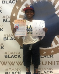 A boy holding up a paper.