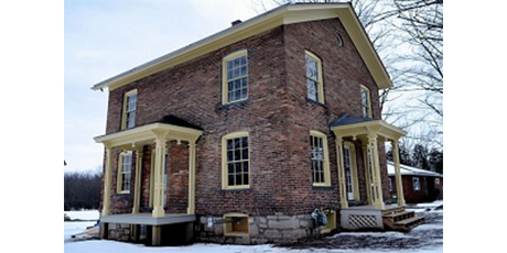 An old brick house in the snow.