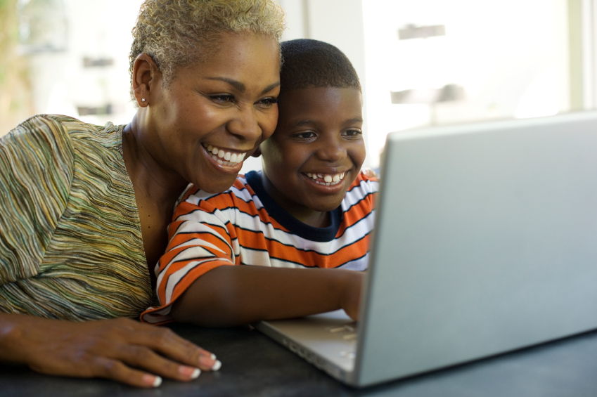 An african-american woman and her son using a laptop computer.