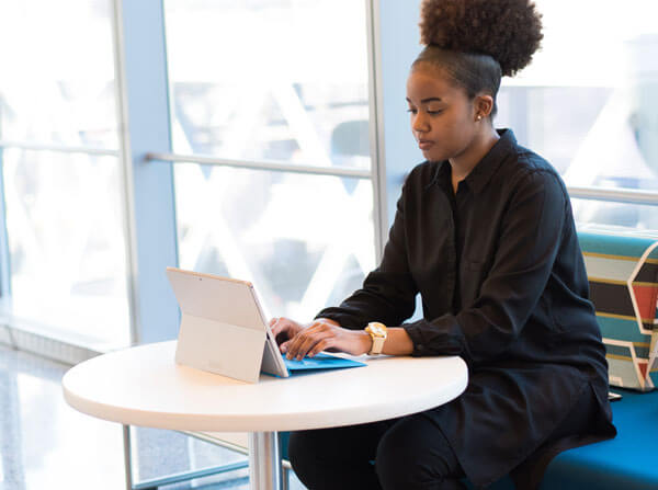 woman working on computer at a round white table