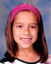 A young girl wearing a pink headband.