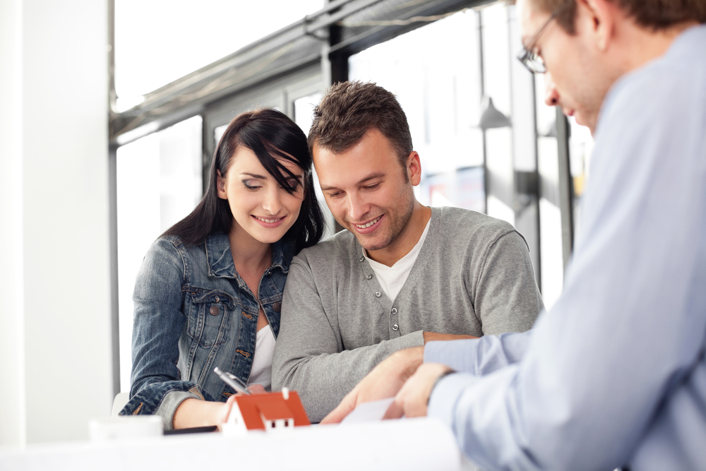 A man and woman looking at a house plan.