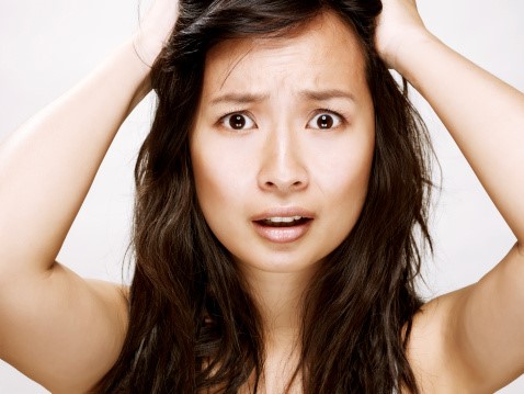 A woman is holding her hair up with her hands.