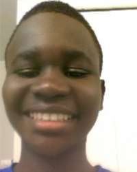 A young man smiling in a blue shirt.