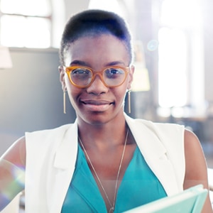 woman wearing glasses smiling holding a book