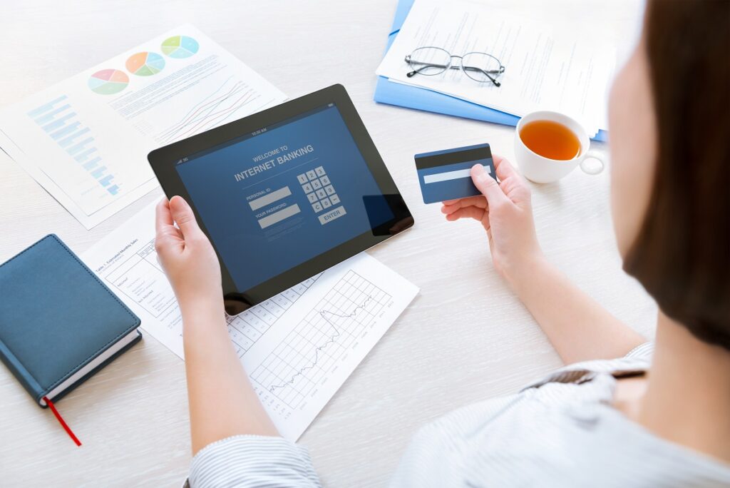 A woman using a tablet and credit card.