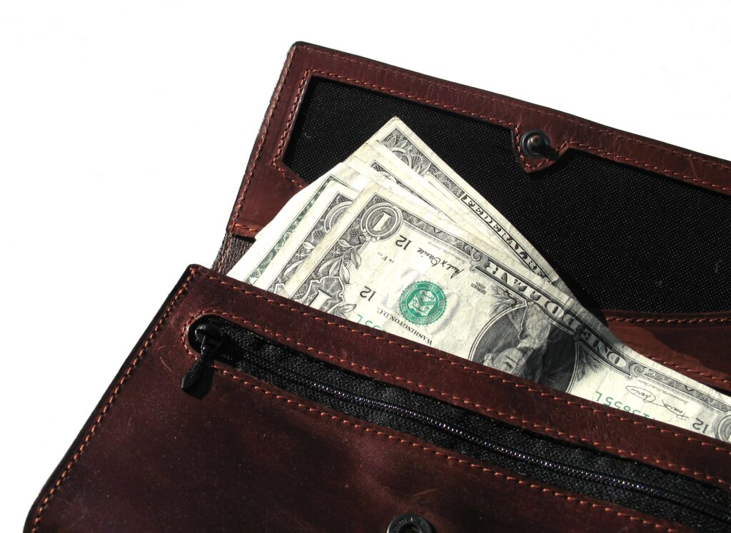 A brown leather wallet with money in it.