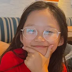 A young girl in glasses is posing for a picture.