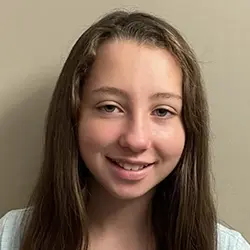 A girl with long hair smiling for the camera.