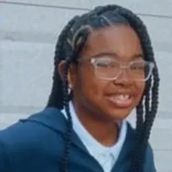 A young girl wearing glasses and a hoodie.