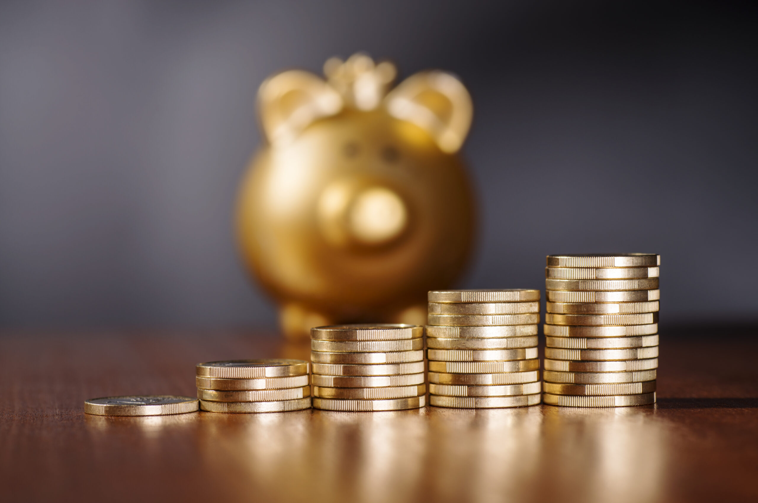 Gold stacks of coins and piggy bank related to Unity E-Gold Savings