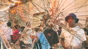 A group of people standing in front of a display of broken glass.