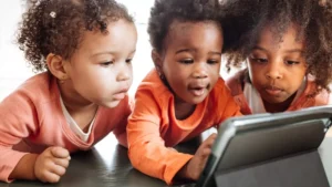 Three young children looking at a tablet computer.