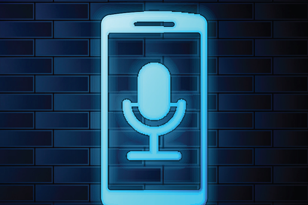 Illuminated phone with podcast microphone in front of brick wall image