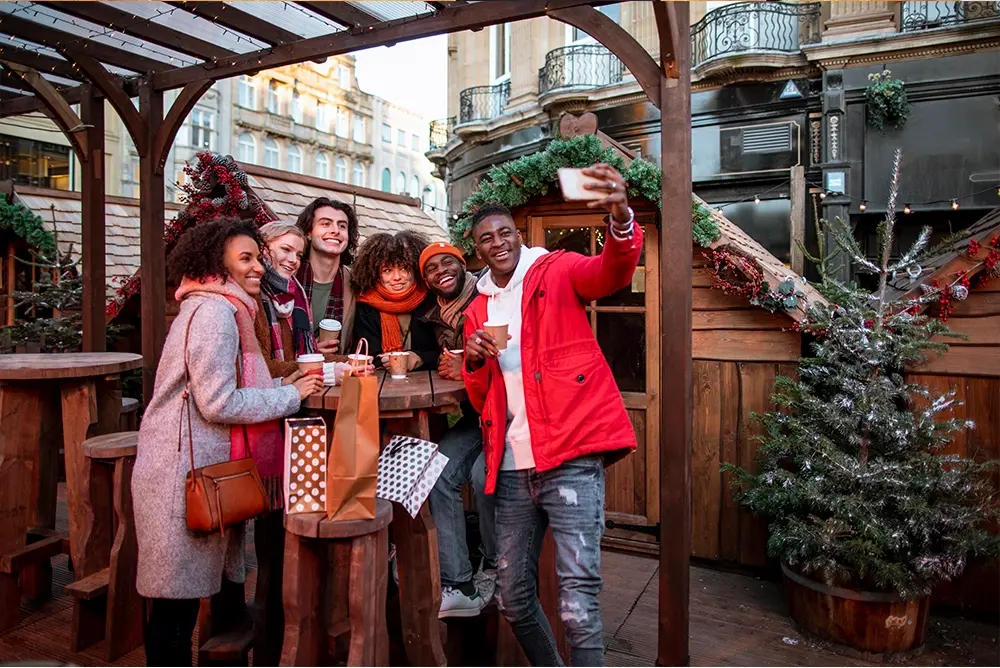 A group of people capturing a selfie at a vibrant Christmas market.