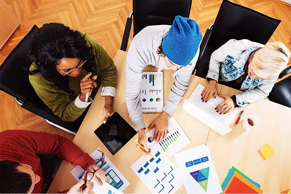 A group of people collaborating around a table to resolve debt-related issues.