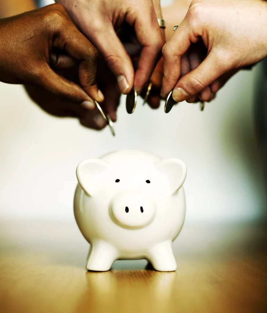 A group of people promoting financial wellness by contributing money into a piggy bank.