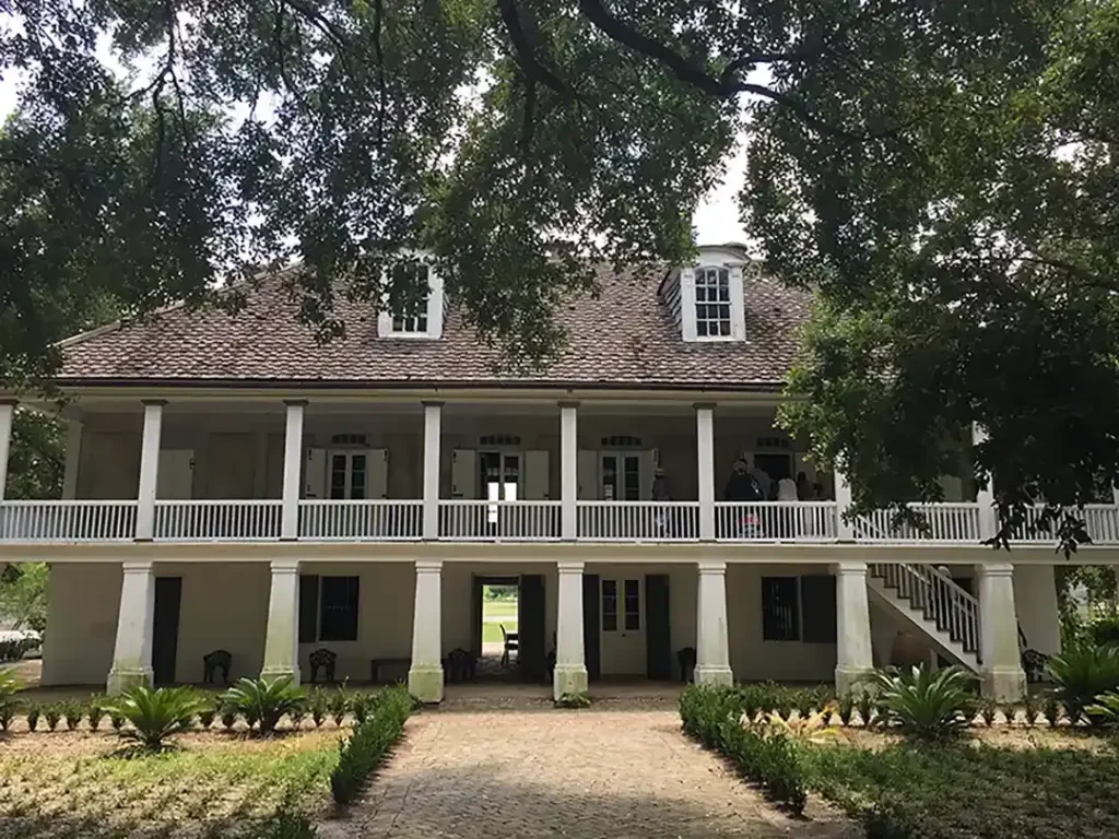 A white house with columns and a walkway.