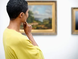 A woman looking at paintings in an art gallery.