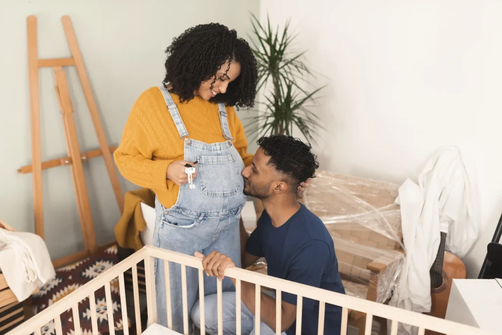 A man and woman standing in front of a baby's crib.