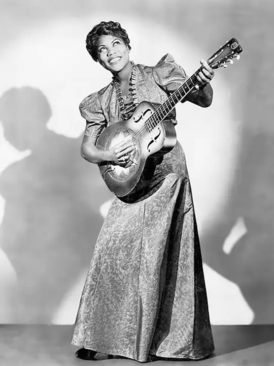 Sister Rosetta Tharpe in an elegant dress holding a guitar, ready to perform rock & roll.