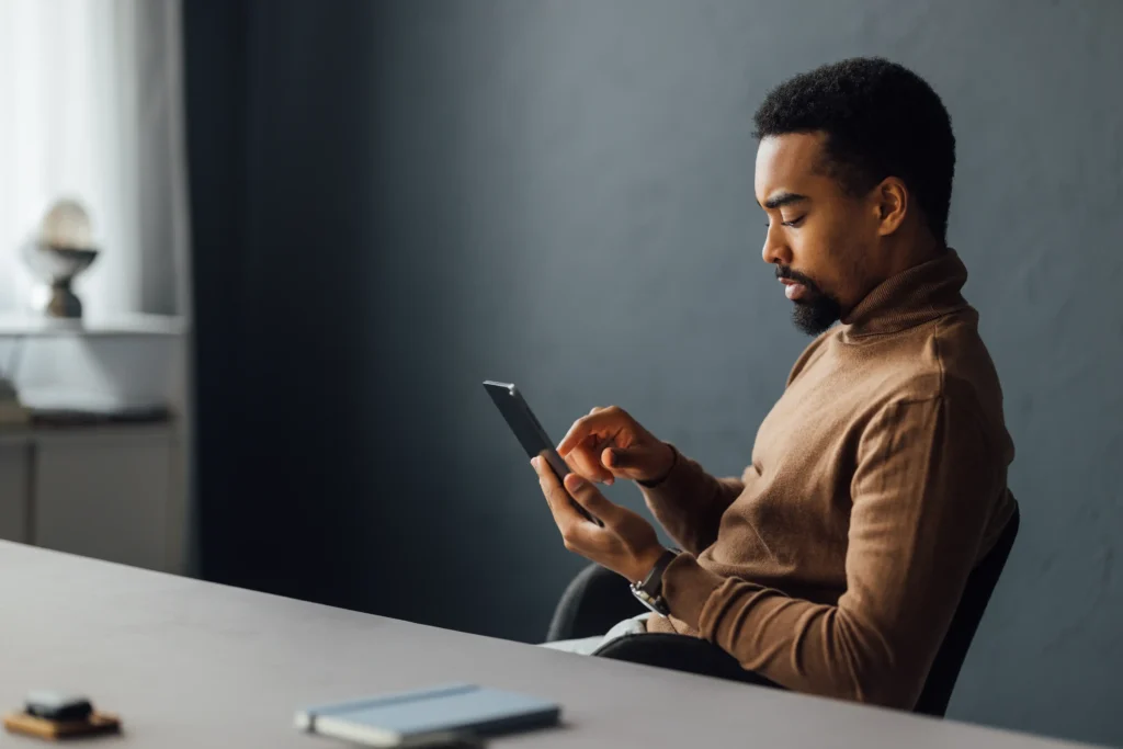 Man sitting at a table focused on his phone