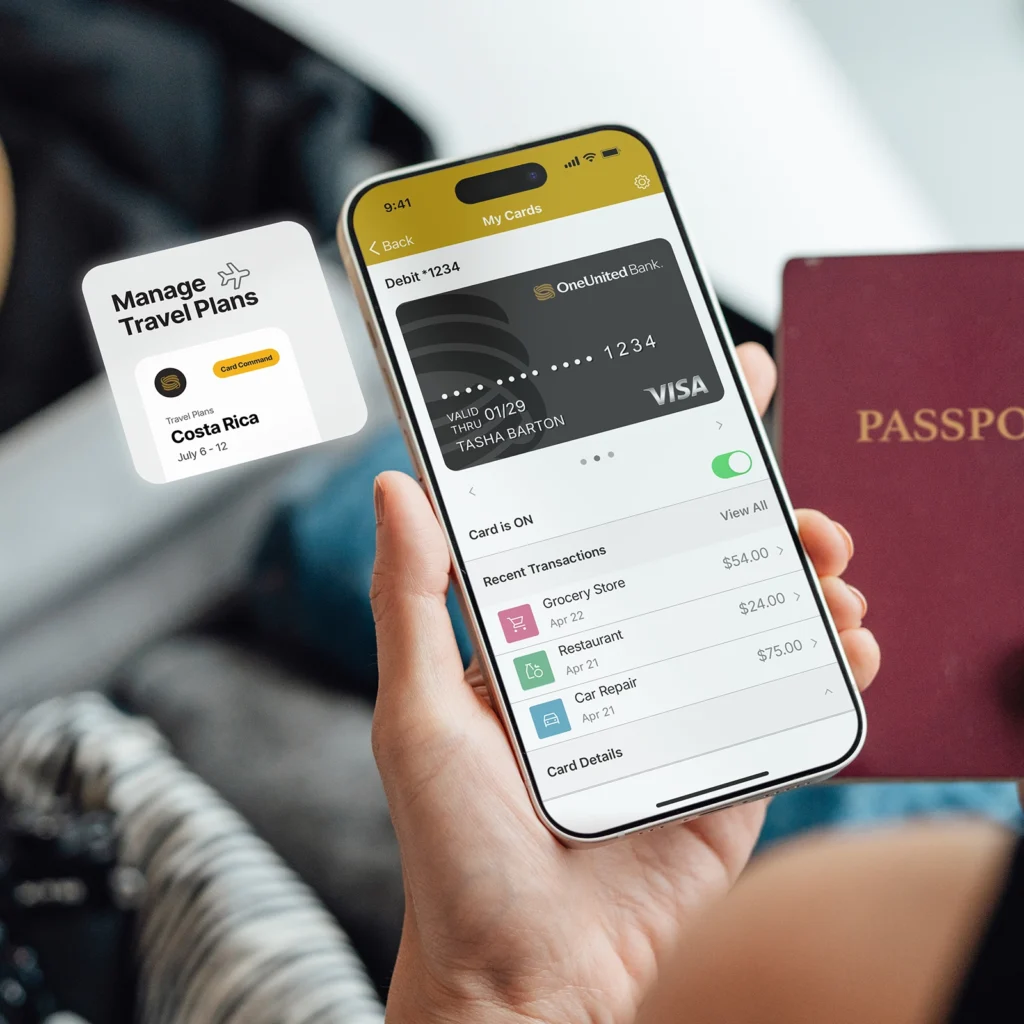 A person holds a smartphone displaying a bank app and a passport, with a travel notification for Costa Rica visible on the screen.
